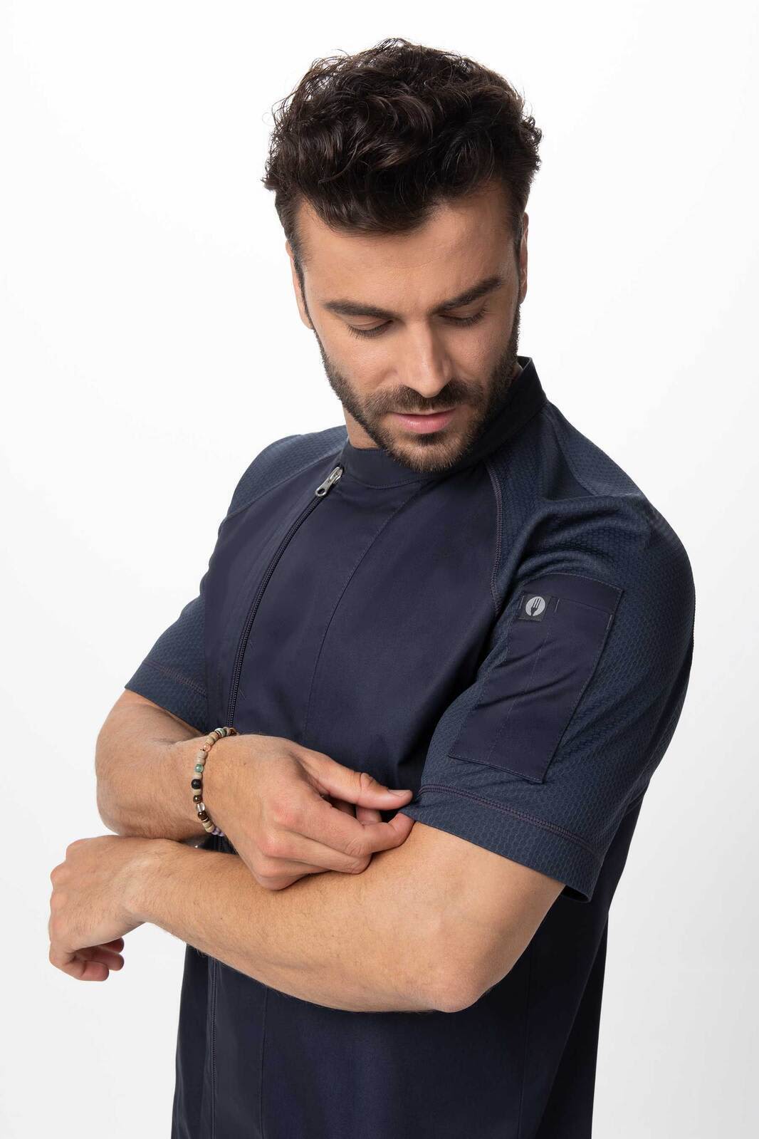 A men's chef jacket in navy blue, featuring short sleeves and a structured design. The jacket includes a logo on the sleeve.