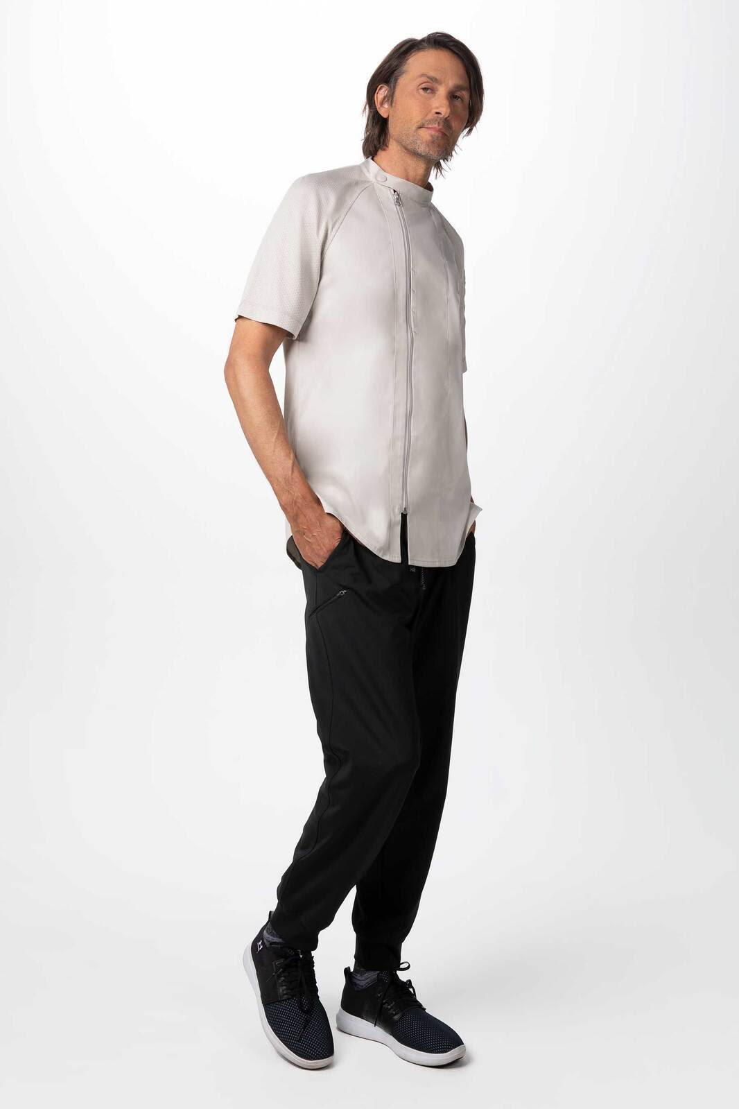 A lightweight, short-sleeved men's chef jacket in light grey, paired with black pants and dark shoes, featuring a logo.