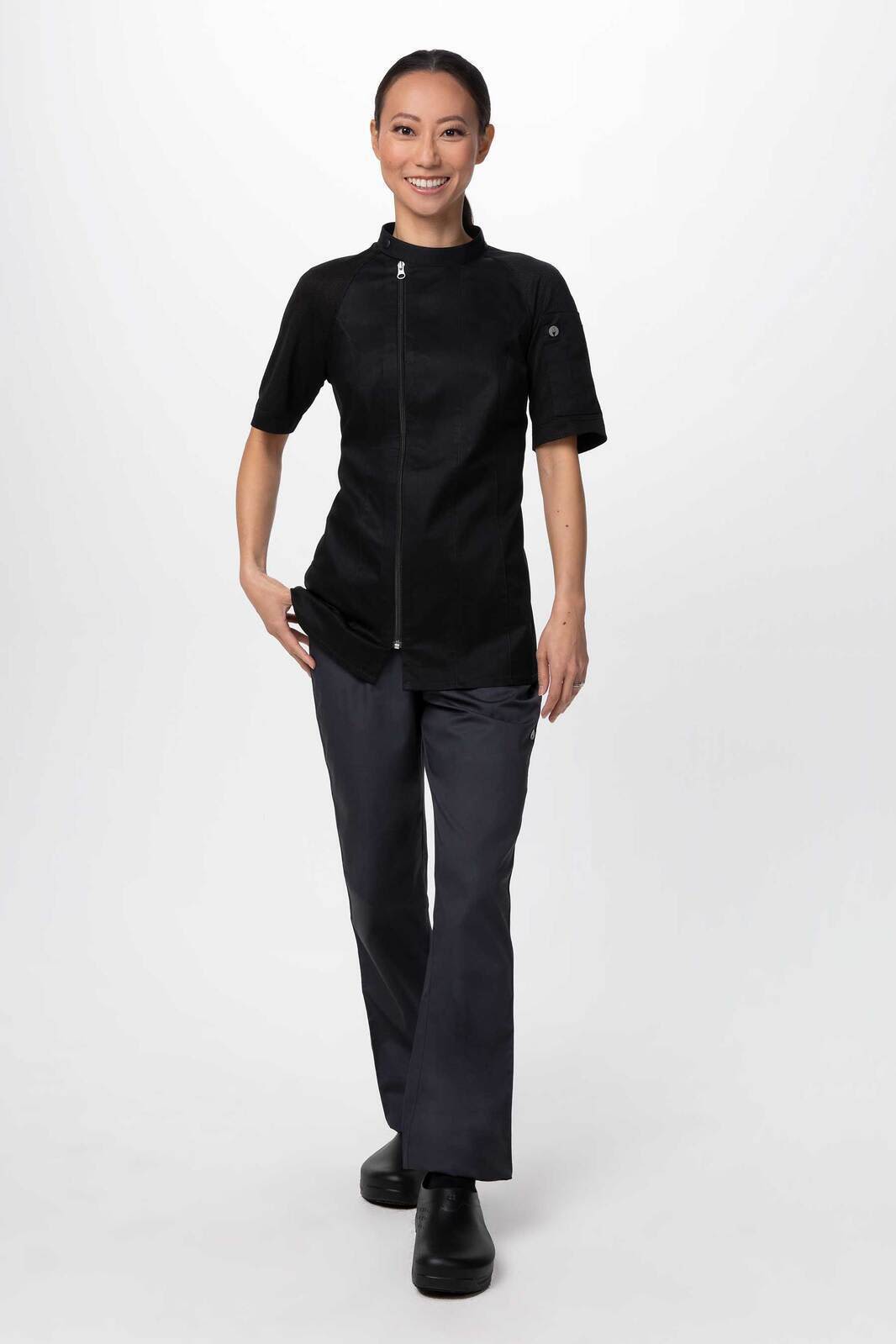 A women's chef jacket in black, featuring short sleeves and a fitted design, paired with grey pants.