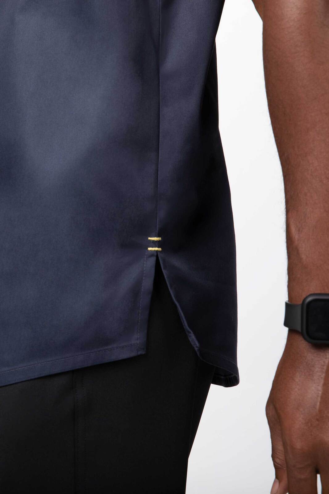 A men's chef jacket in navy with gold detailing at the side split and a branded logo.