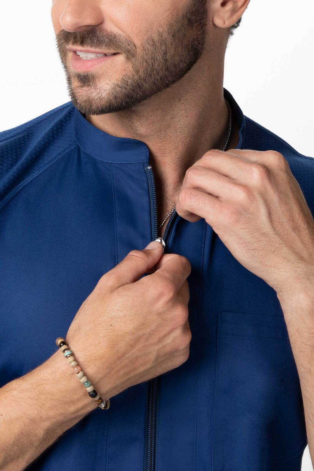 A men's chef jacket in navy blue, featuring a zip closure and a modern design. The model is adjusting the jacket.