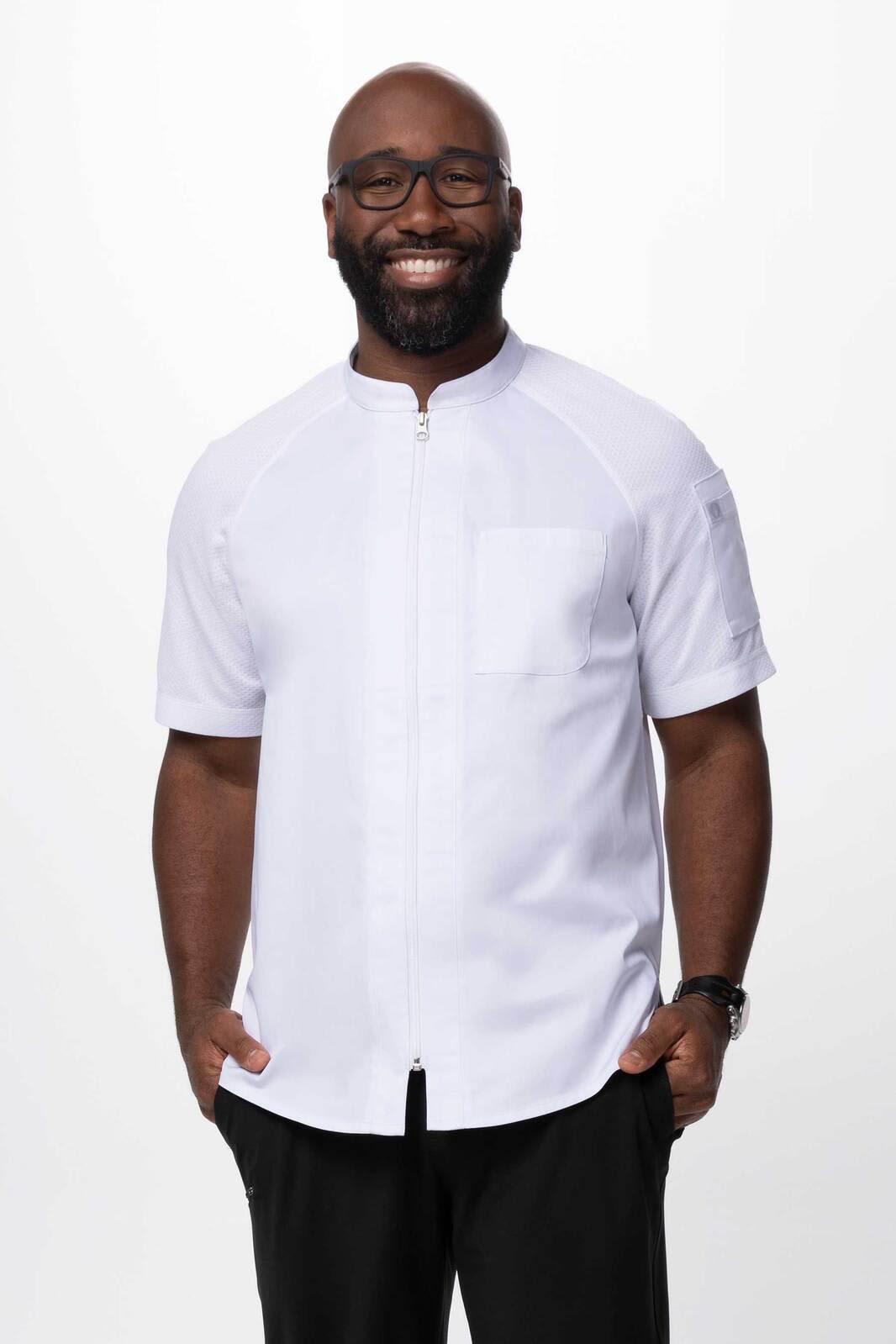 A white men's chef jacket featuring a front zip and a pocket, modelled by a smiling man.
