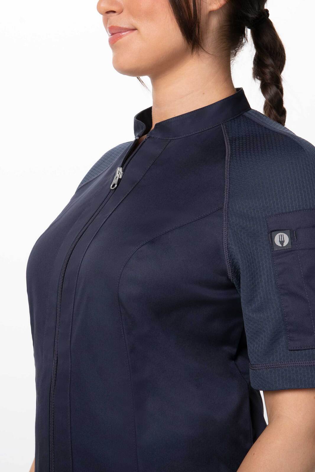 A women's chef jacket in navy blue, featuring a zip front and short sleeves, with a logo detail on the arm.