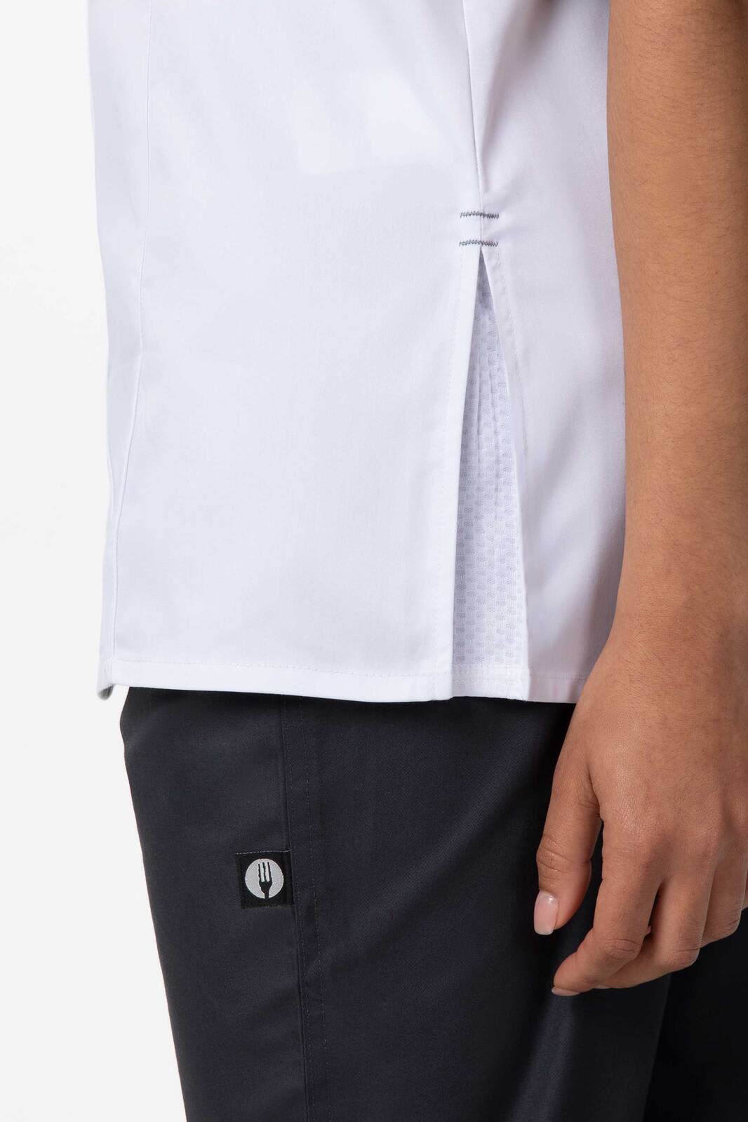 A women's chef jacket in white, featuring a side slit and a logo on the sleeve.