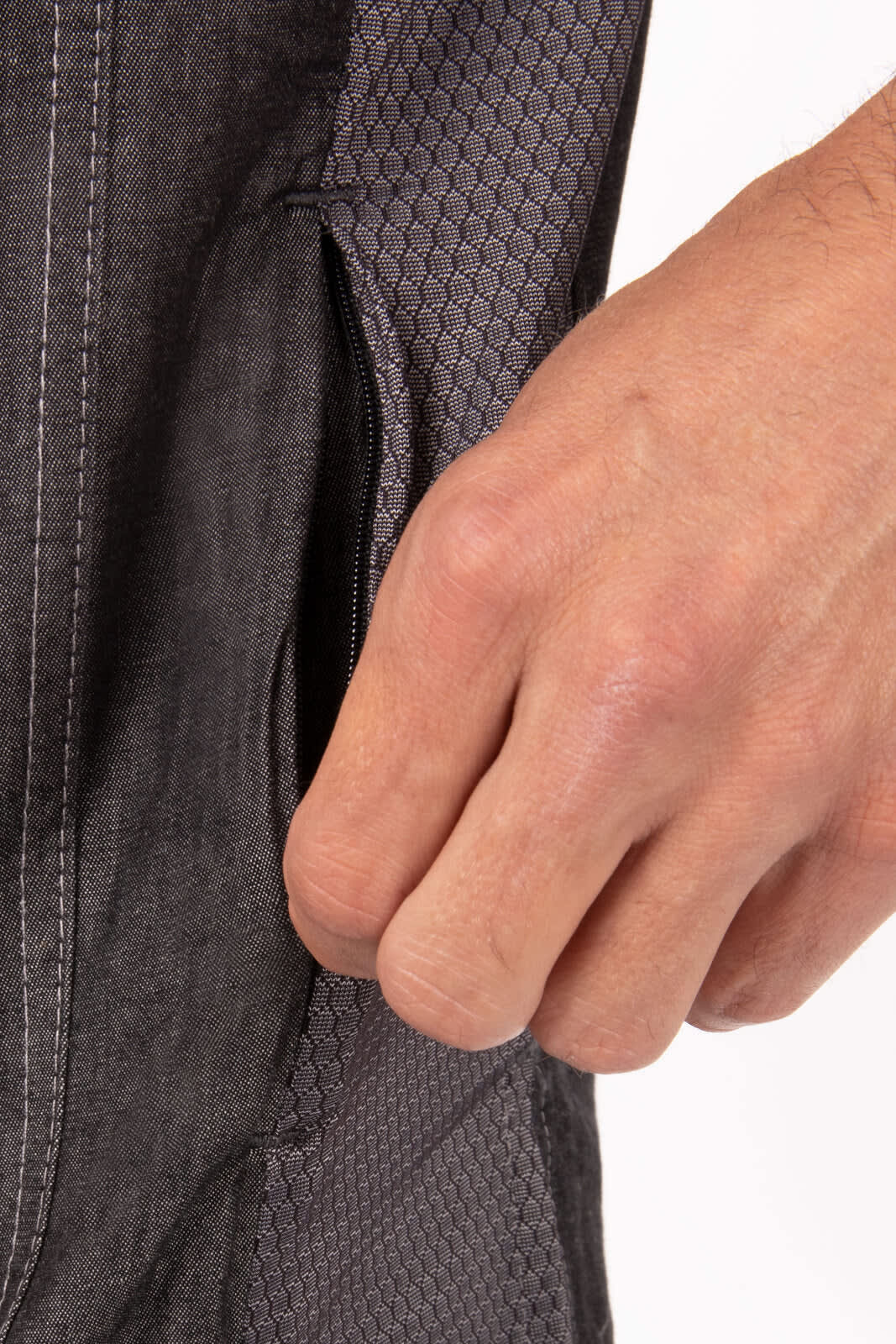 A grey chef jacket featuring a textured fabric and a functional side pocket, showcasing a hand reaching for the pocket.