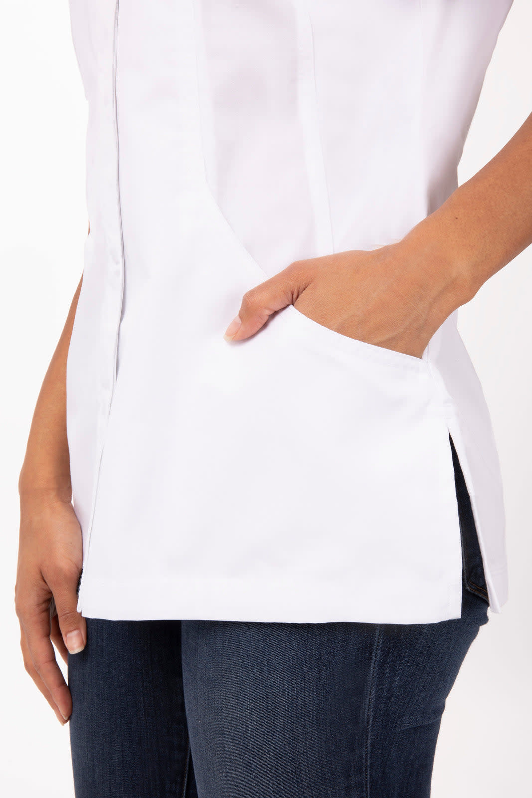 A white women's chef jacket featuring a side pocket, styled with slim-fit jeans for a professional look.