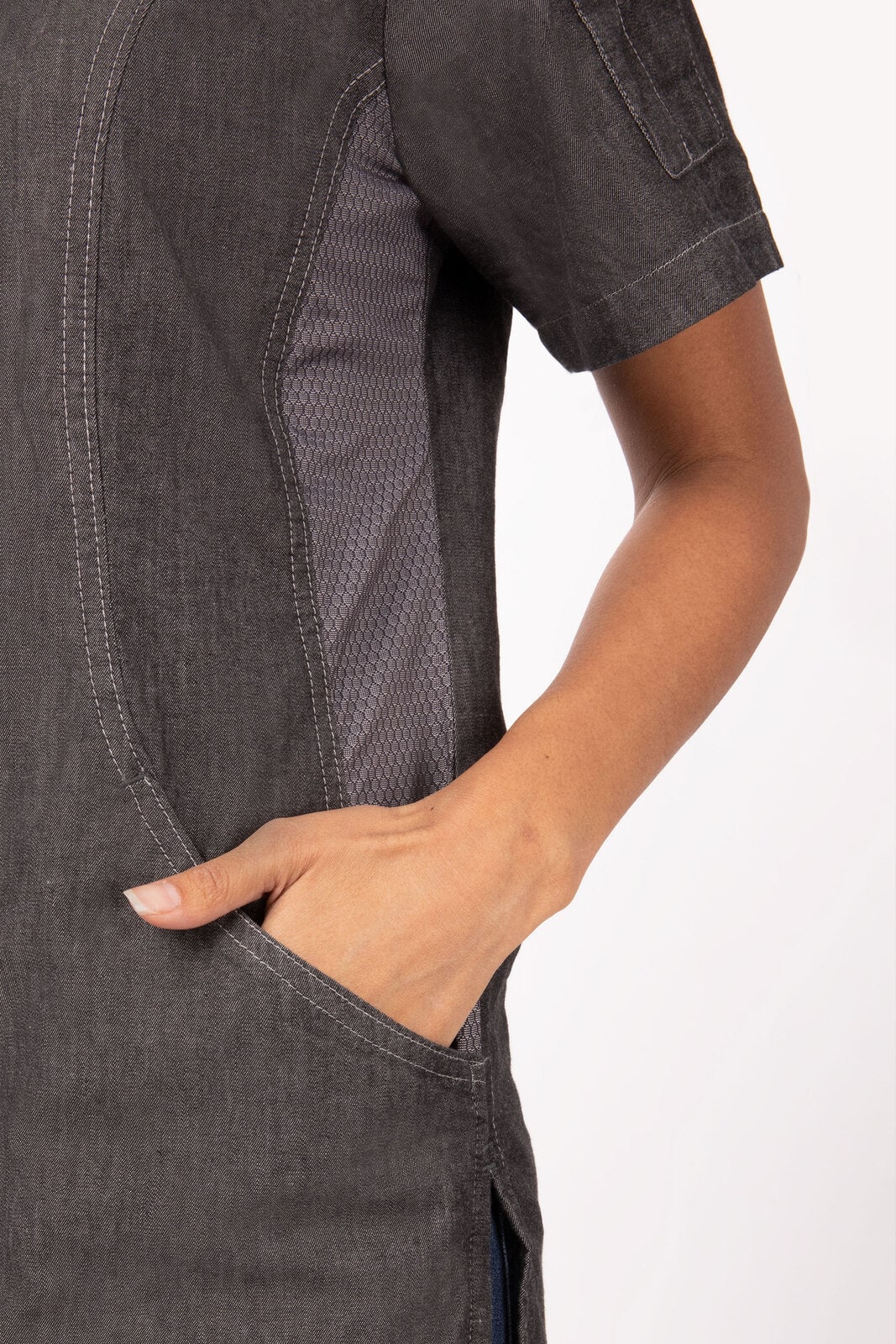 A grey chef jacket featuring a stylish design with mesh panels and a hand in the side pocket.