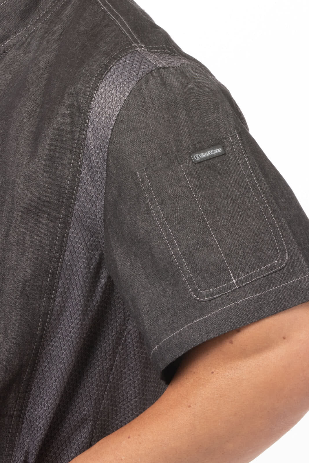 A close-up of a dark grey men's chef jacket featuring a textured design and a pocket on the sleeve.