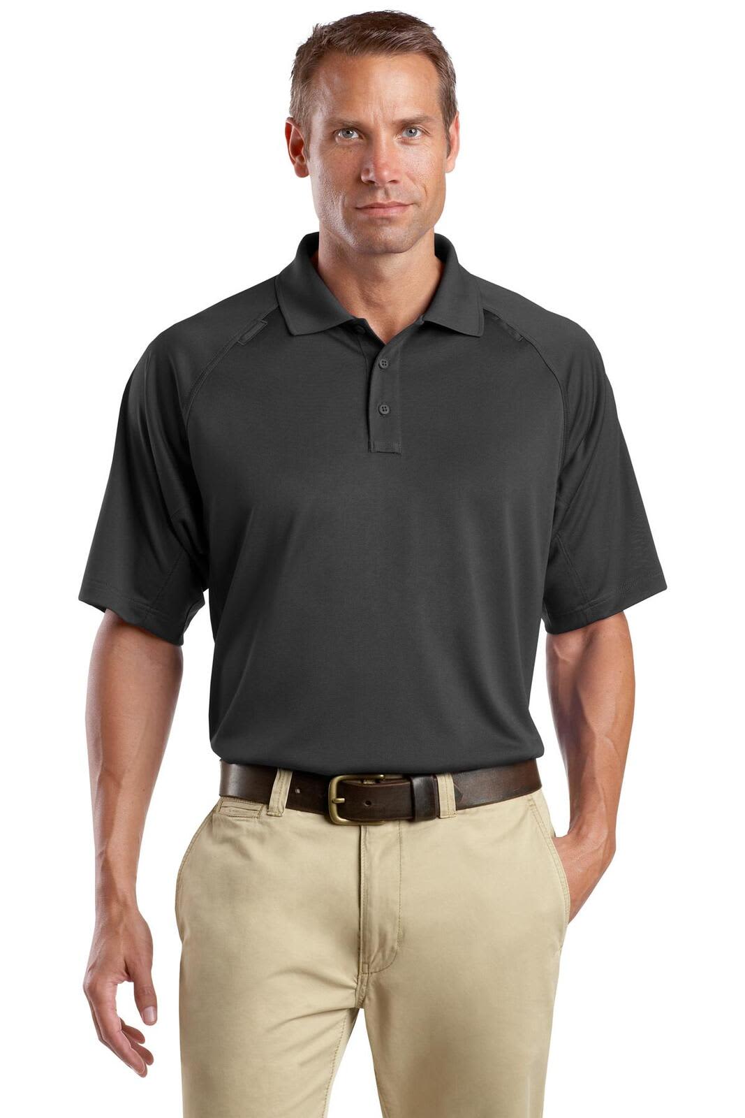 A man wearing a black snag-proof tactical polo shirt, paired with light-coloured trousers. The shirt has a logo.