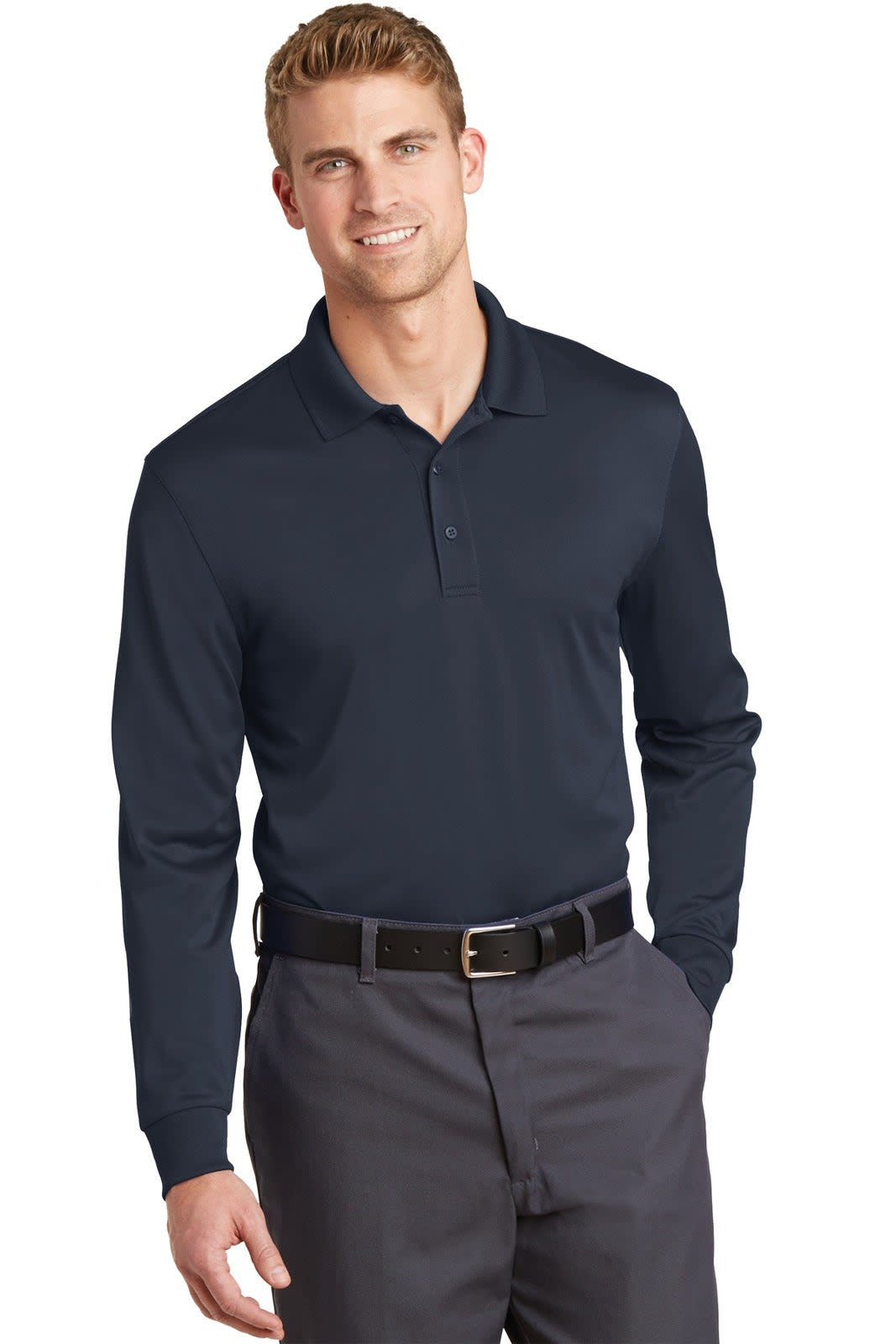 A man wearing a navy long sleeve polo shirt with a collar, paired with dark trousers and a belt.