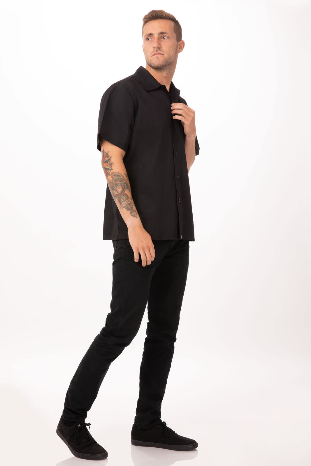 A black short-sleeve cook shirt worn by a male model, paired with black pants and shoes, featuring a logo.