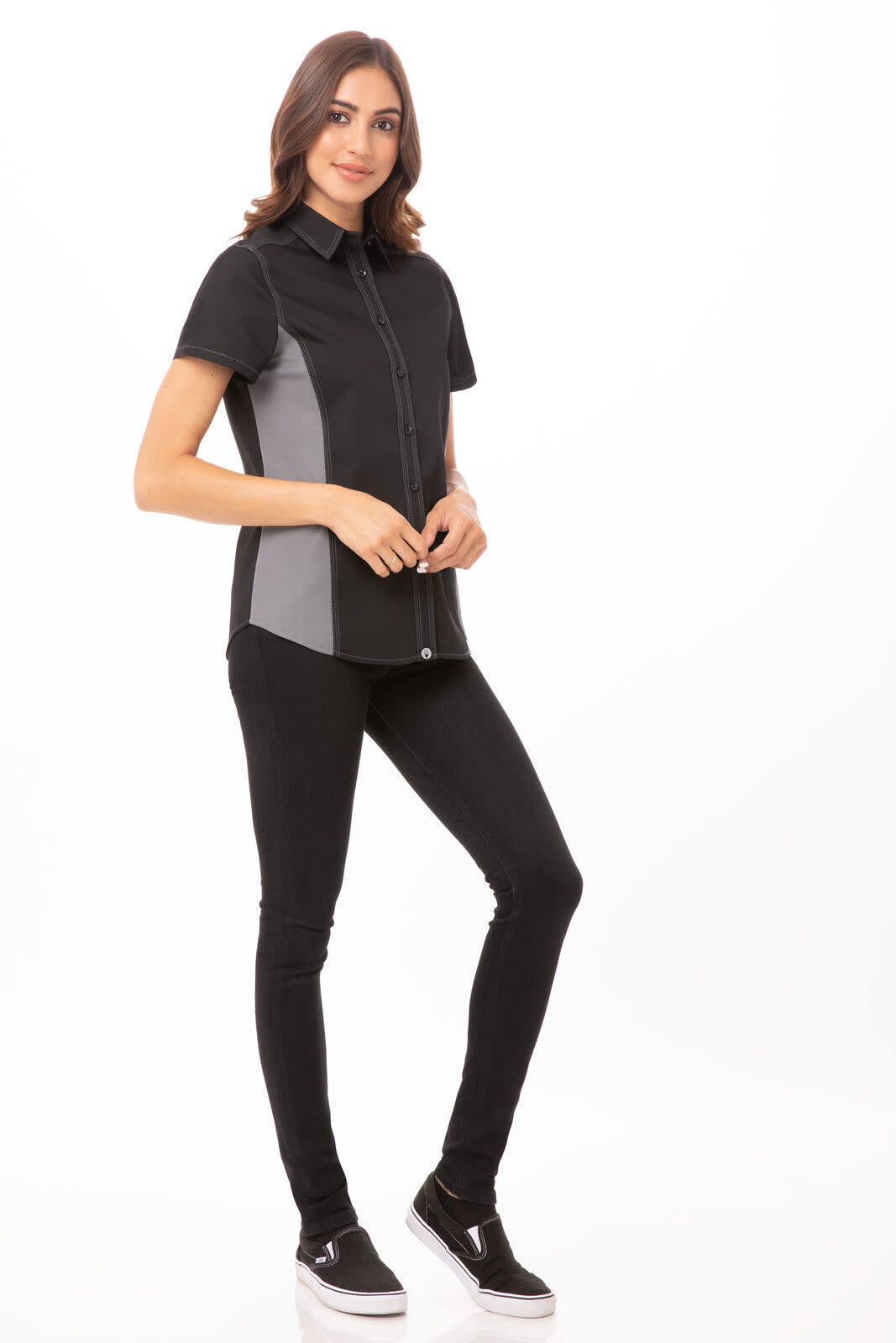 A women's short-sleeve shirt in black and grey with a fitted design, worn with black pants and casual shoes.