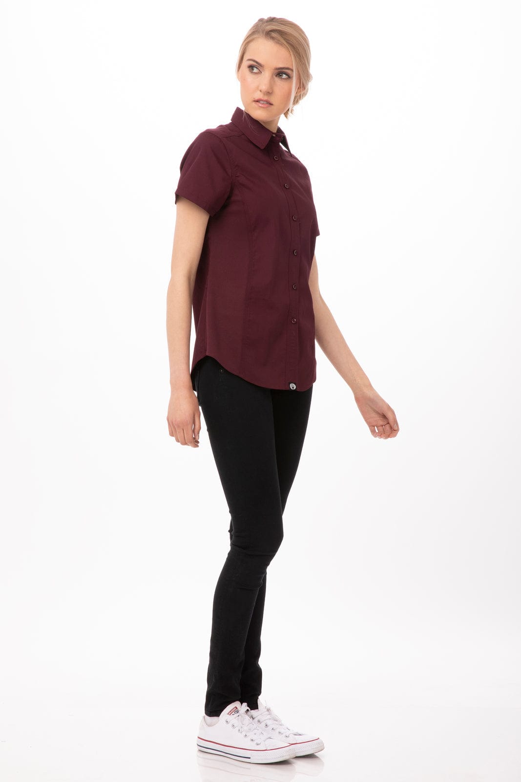 A maroon short-sleeve shirt is displayed, paired with black pants and white sneakers. The shirt features a button-up design and a logo.