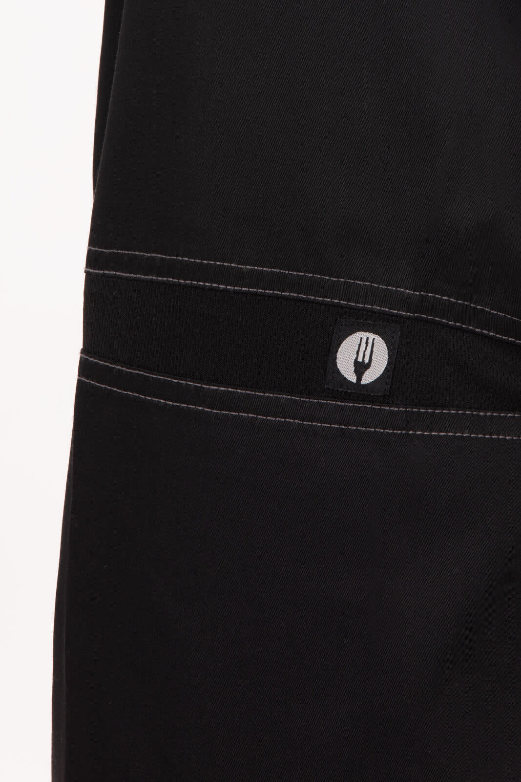 Black baggy chef pants featuring a logo on the waistband and contrasting stitching.