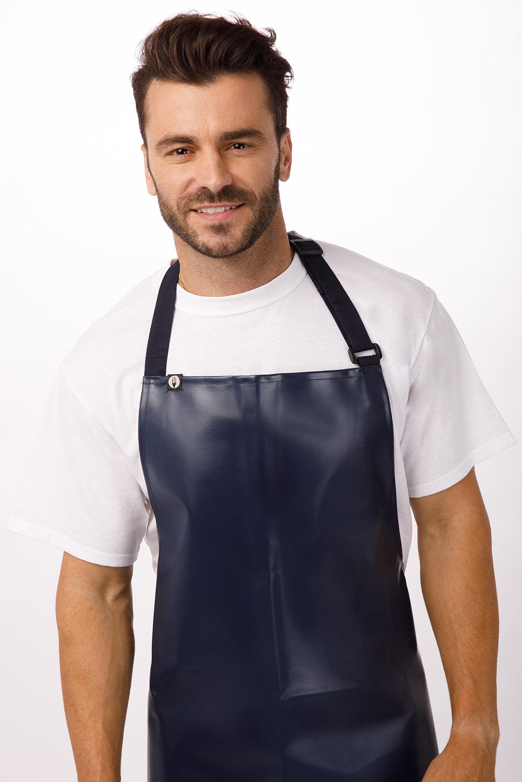 A navy blue PVC bib apron with adjustable straps worn by a smiling man. The apron features a logo.