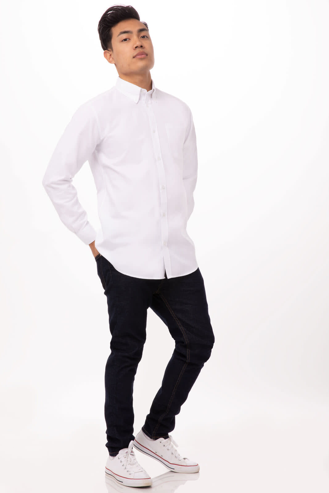 A white Oxford button-up shirt worn by a model with black jeans and white sneakers, featuring a logo.
