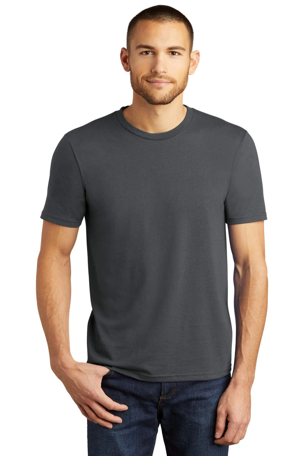 A man wearing a grey t-shirt stands with one hand on his hip, paired with denim jeans. The t-shirt features a logo.
