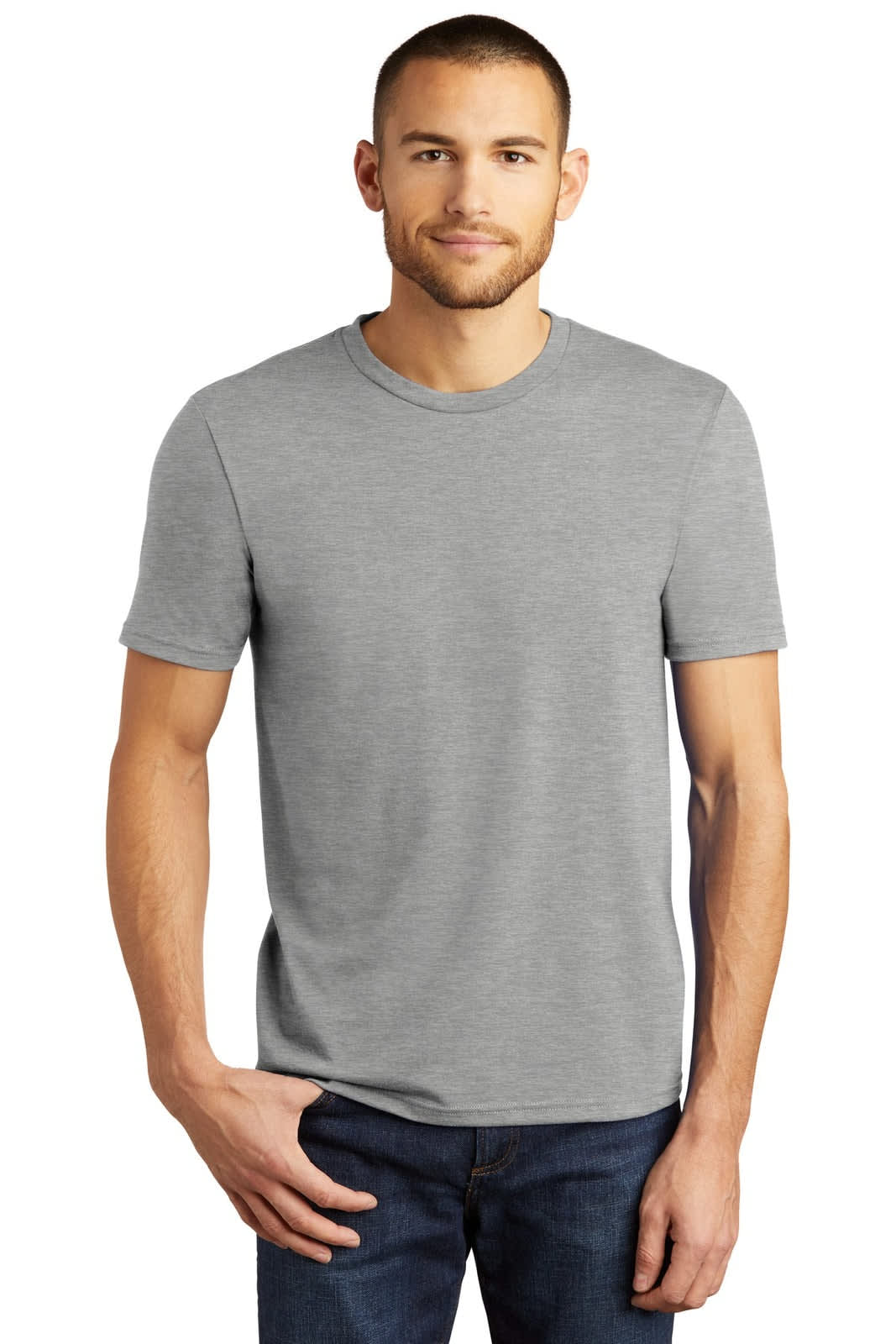 A man in a light grey short-sleeve t-shirt stands with one hand on his hip. The shirt has a simple design and a logo.