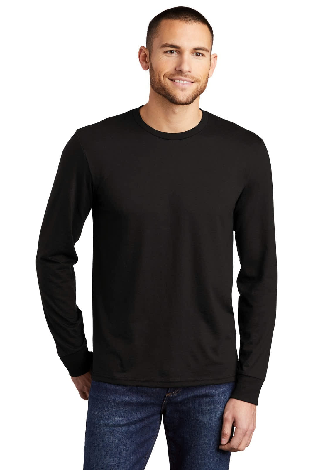 A man models a black long sleeve crew tee. The shirt has a logo on it and is paired with blue jeans.
