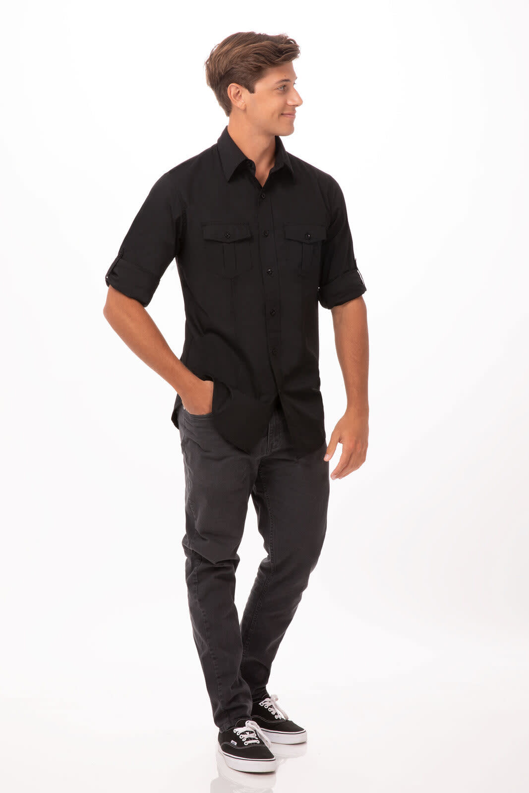 A black button-up shirt with short sleeves, featuring two chest pockets, worn by a model in casual pants and shoes.