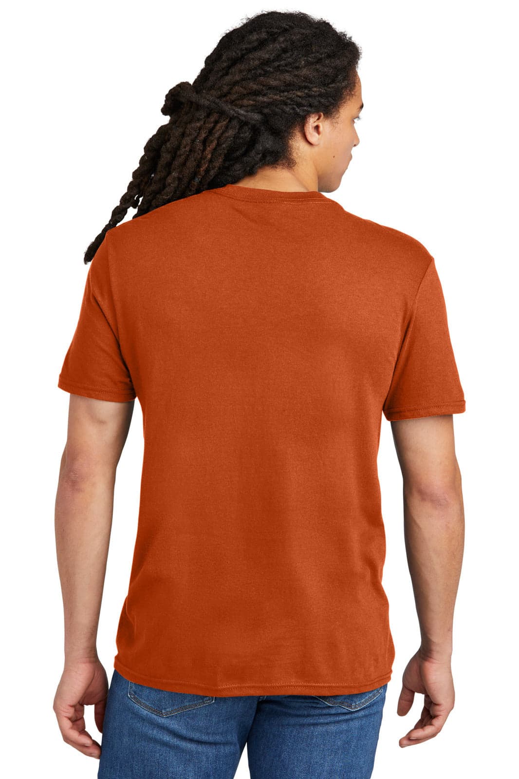 A young man with dreadlocks wearing an orange T-shirt, viewed from the back, standing in a casual pose.