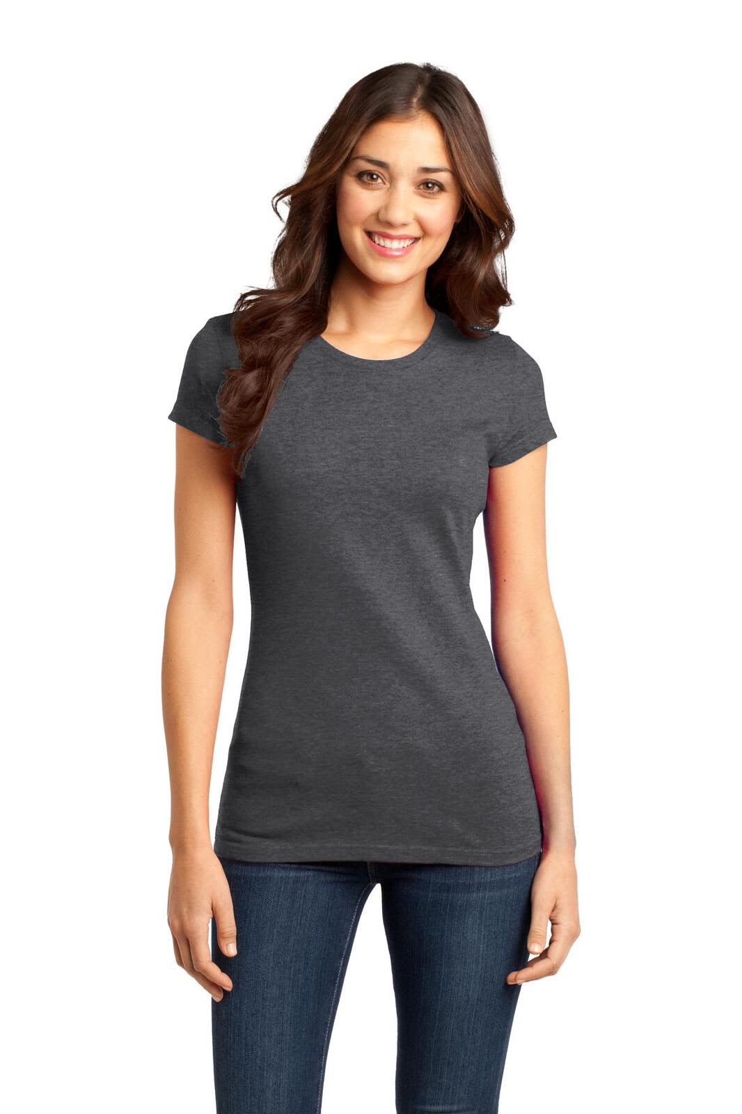 A woman wearing a grey juniors t-shirt with short sleeves, paired with dark jeans. The shirt has a logo.