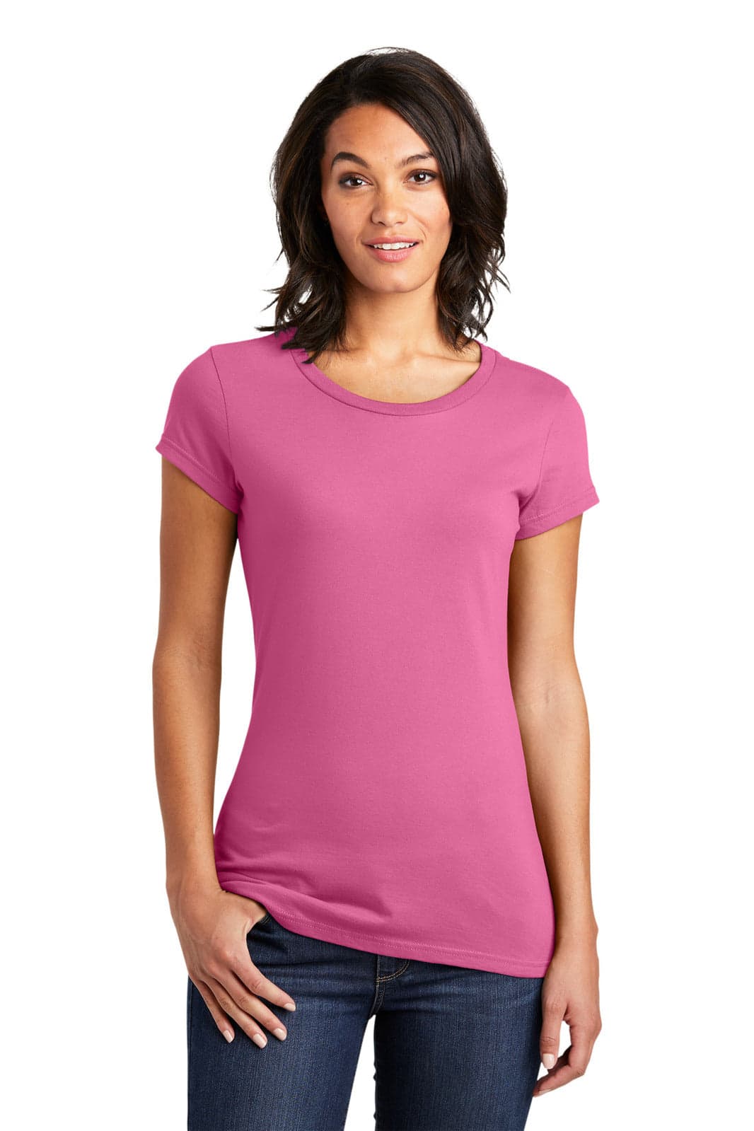 A woman models a pink juniors T-shirt with short sleeves. The shirt has a subtle branding logo.