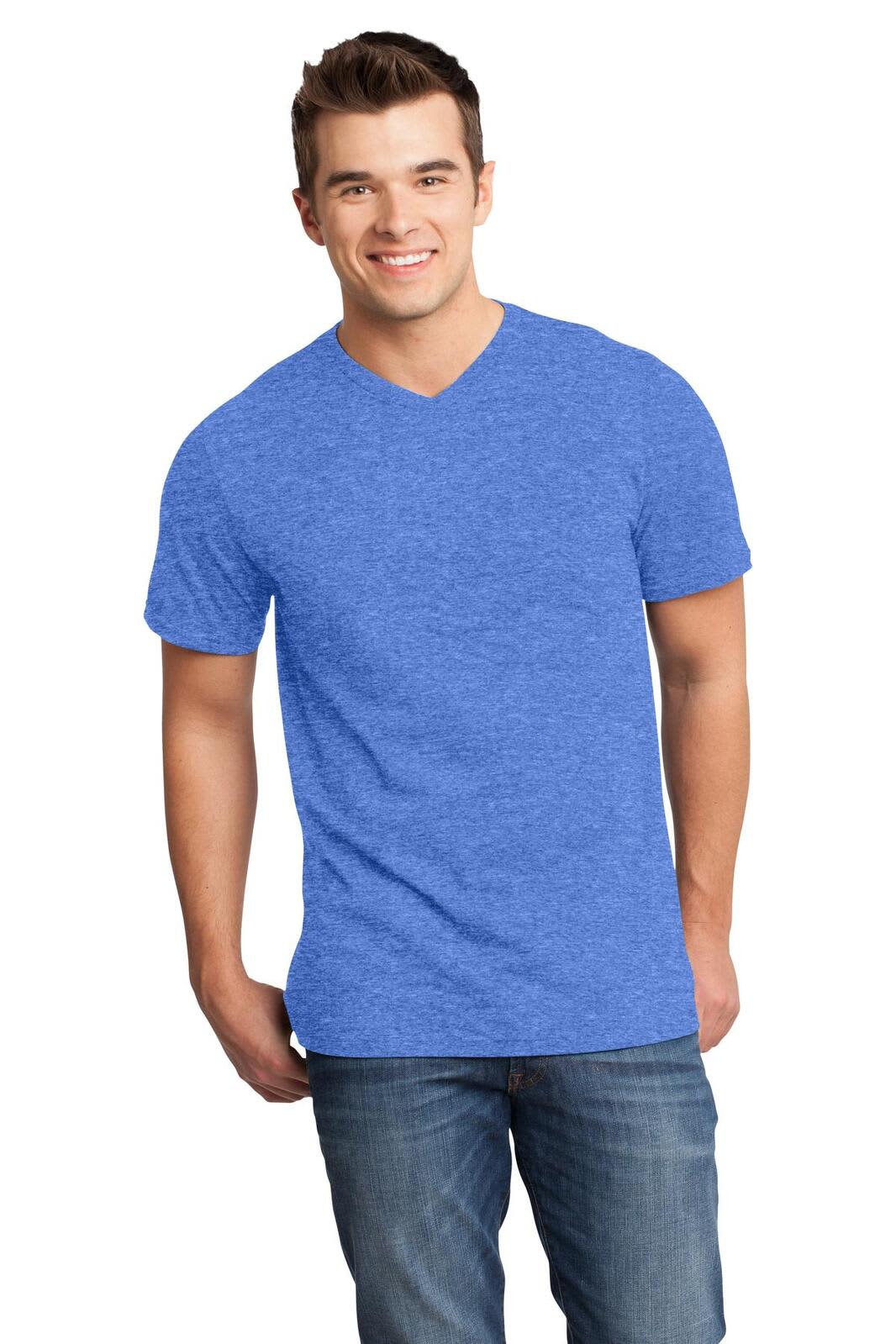 A young man is wearing a blue v-neck t-shirt and jeans, smiling towards the camera. The shirt has a logo.