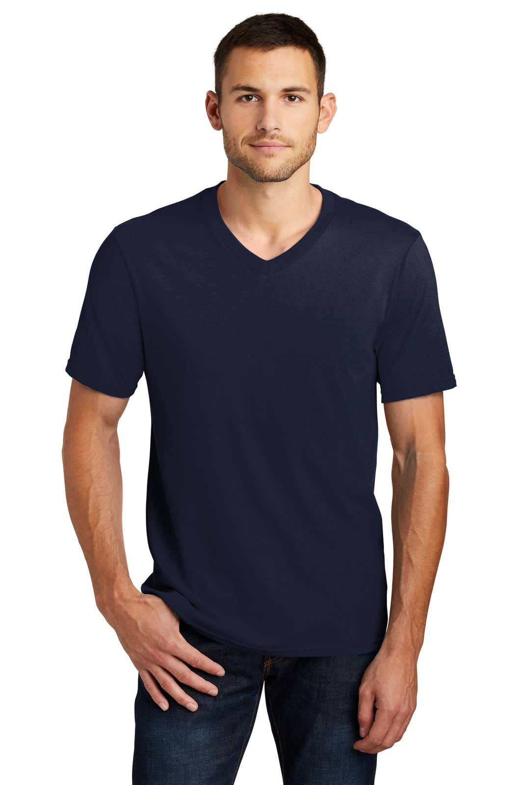 A young man is wearing a navy v-neck t-shirt, paired with blue jeans. The shirt features a branding logo.