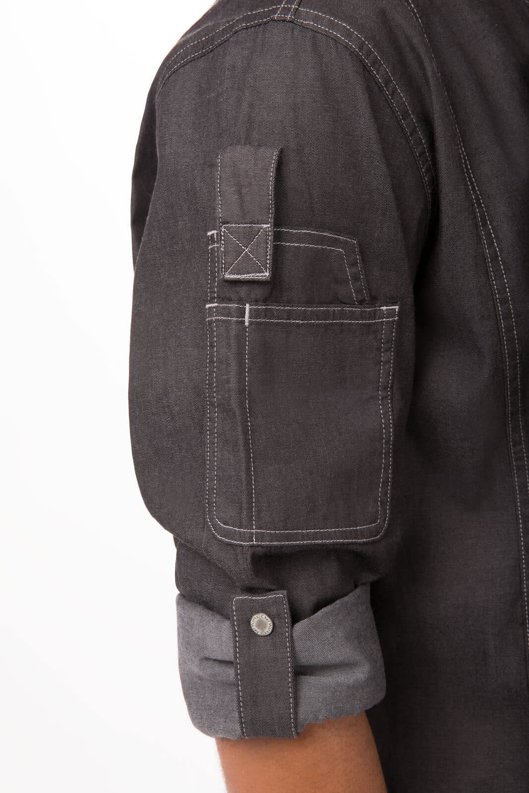 A dark grey denim chef jacket with a rolled-up sleeve and a pocket on the arm. Features a button closure.