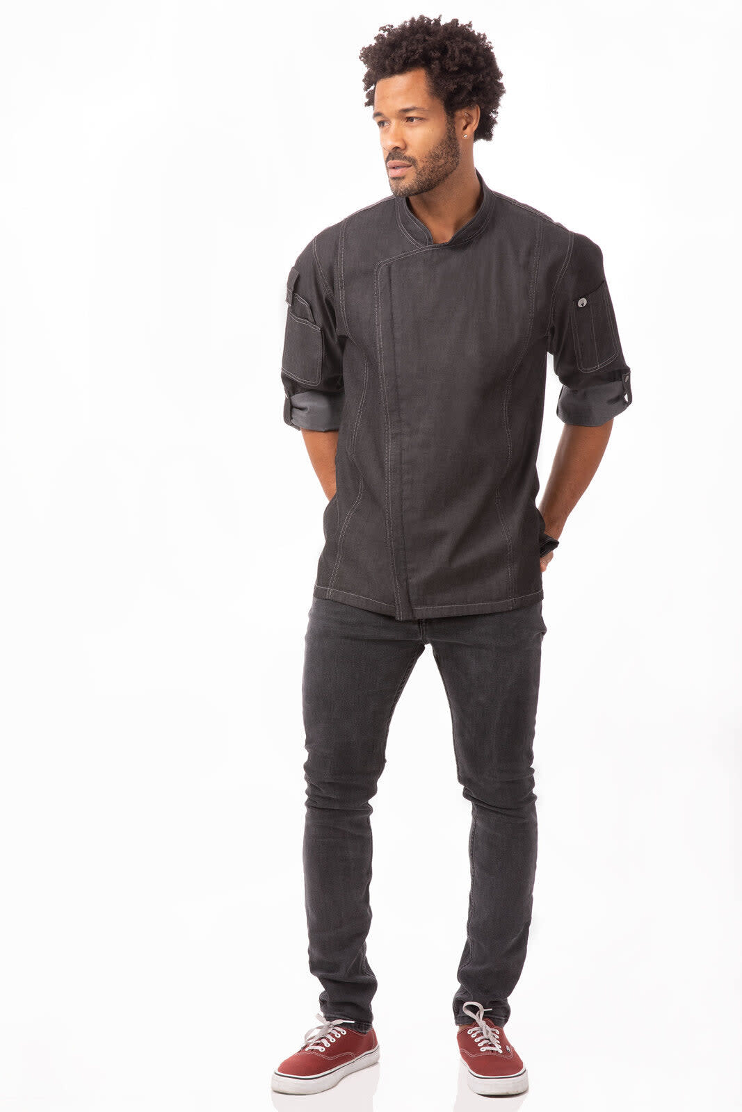 A black denim chef jacket worn by a man, paired with dark jeans and red shoes. The product features a logo.
