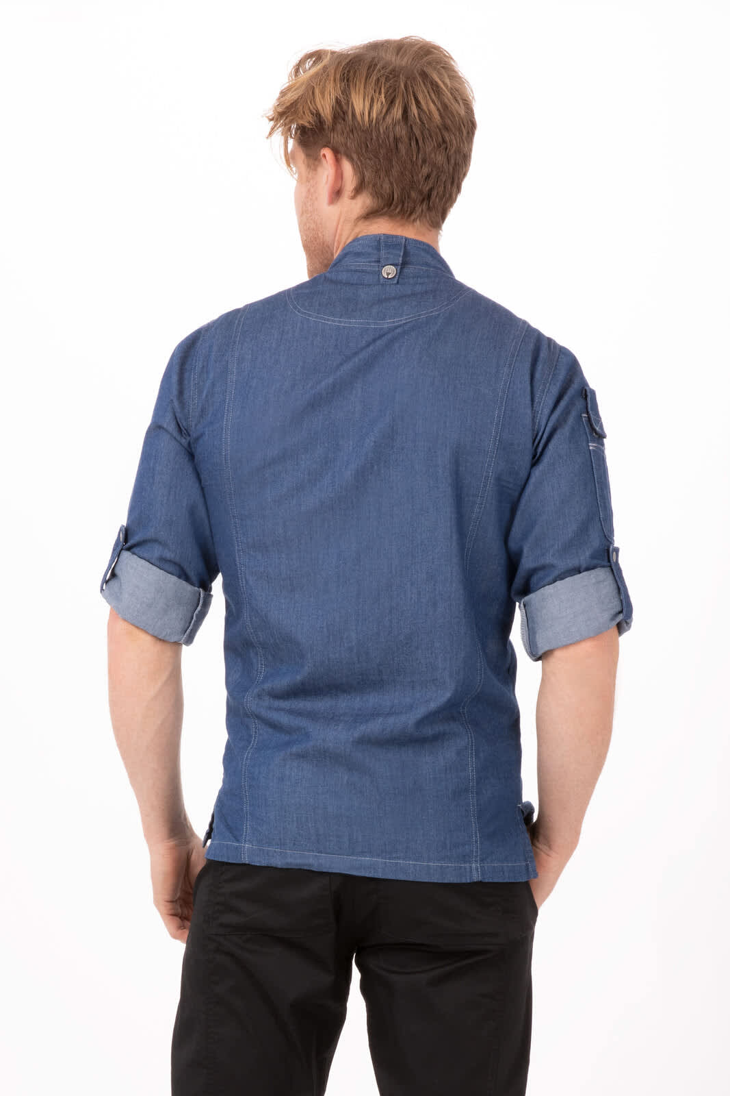 A denim chef jacket featuring rolled sleeves and a back button detail, worn by a man.