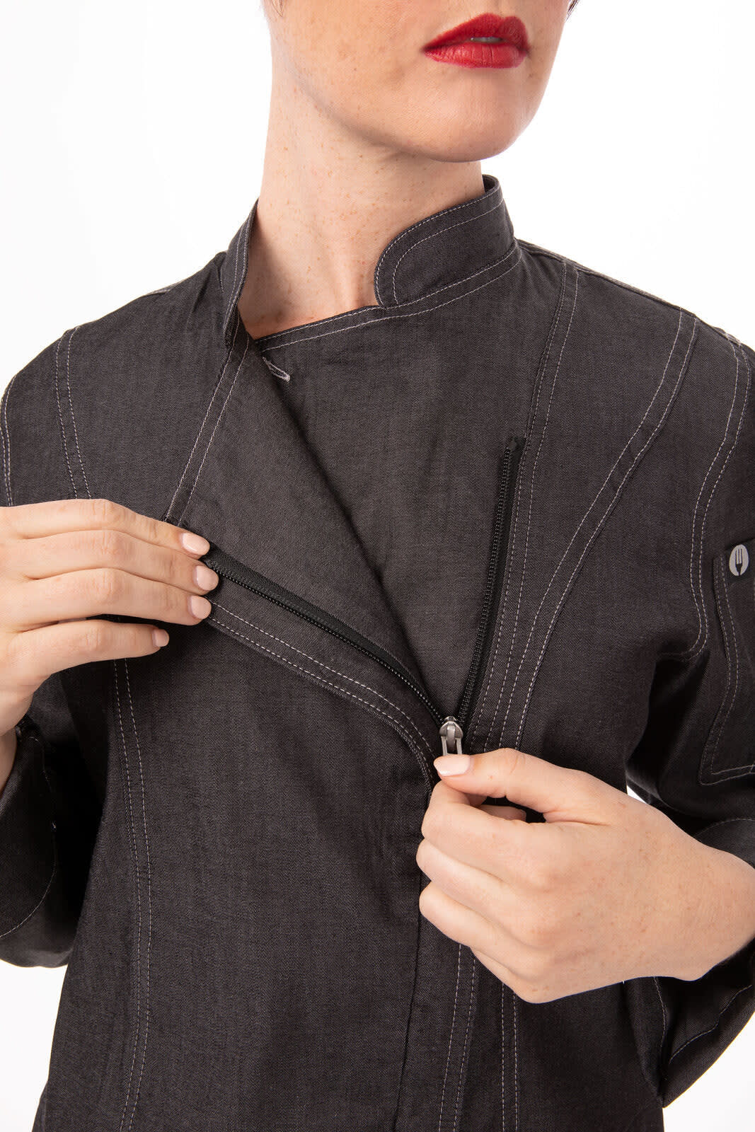 A black denim chef jacket featuring a zip closure and a stylised collar, with a logo on the sleeve.