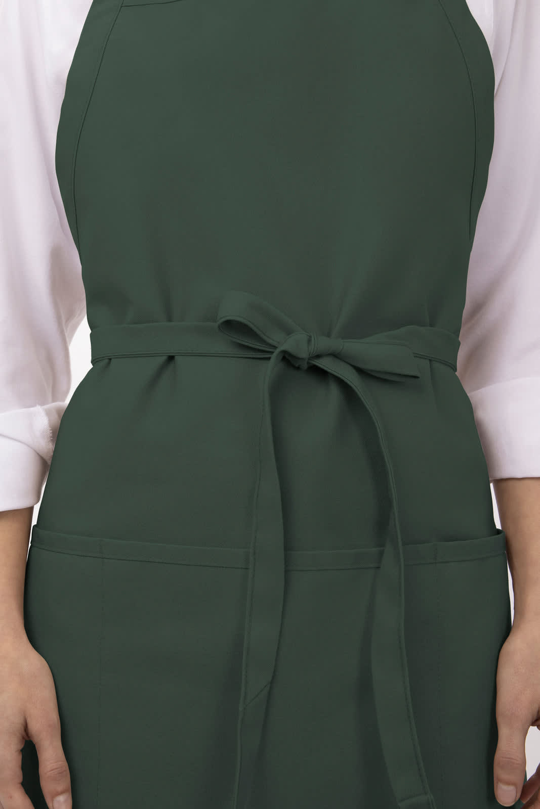 A dark green three-pocket apron with a tied waist and a person’s hands holding the sides.