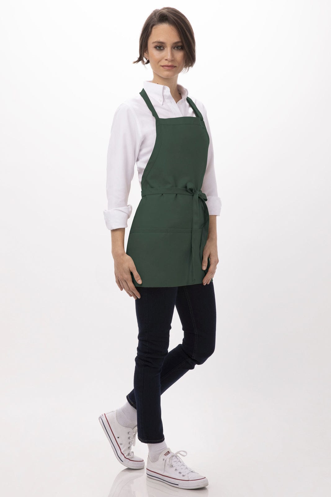 A green three-pocket apron worn over a white shirt, featuring adjustable straps and a tied waistband.