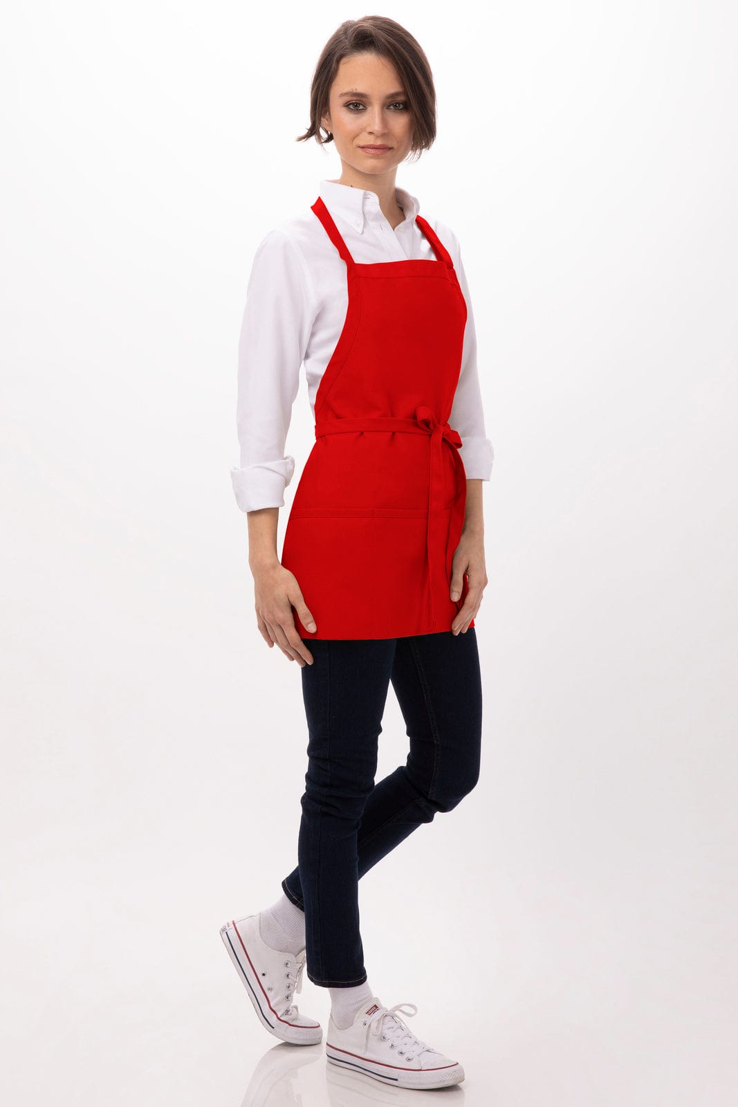 A red apron with three pockets, worn over a white shirt and dark trousers, featuring a logo.