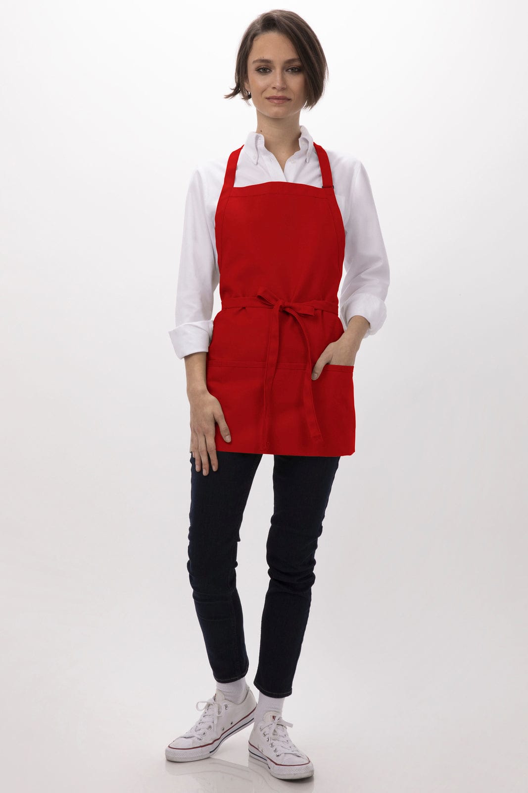 A red three-pocket apron worn over a white shirt, paired with dark jeans and white sneakers. Features a logo.