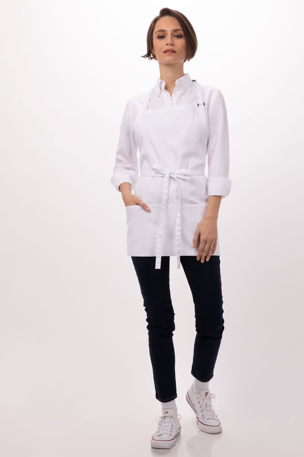 A white three-pocket apron with sleeves, worn by a model paired with dark pants and white sneakers. Features a logo.