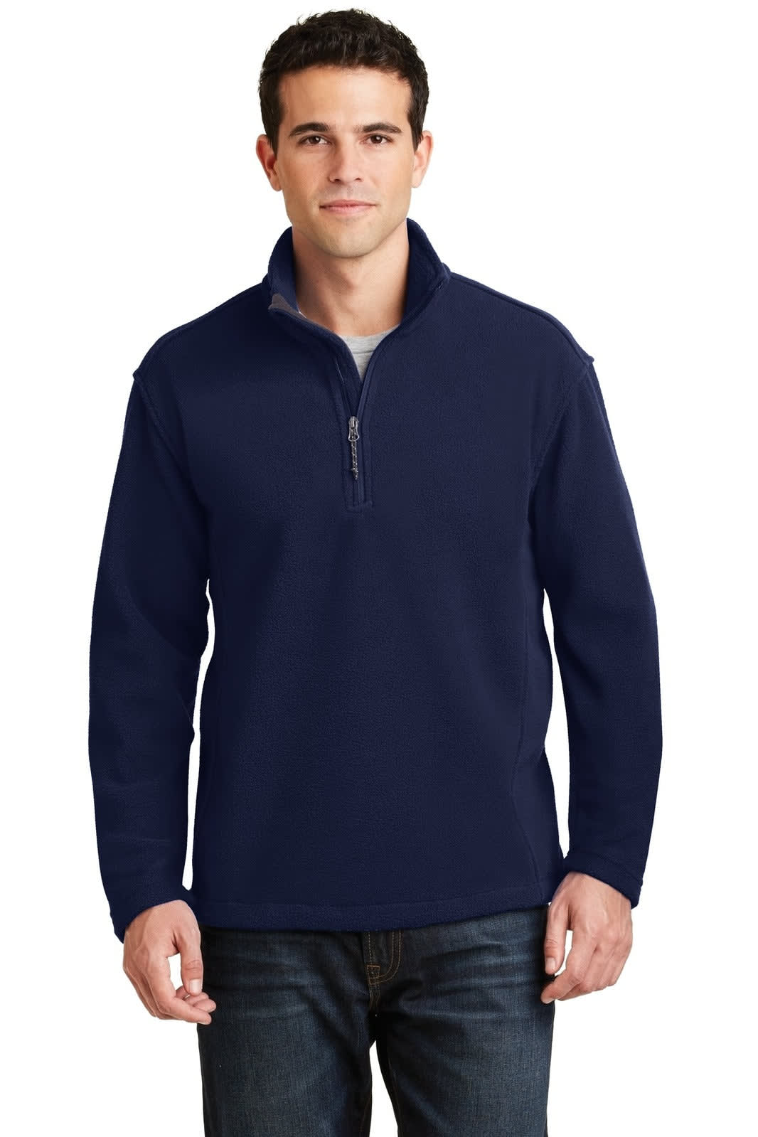 A man wearing a navy fleece 1/4-zip pullover, paired with dark jeans, and a logo visible on the pullover.