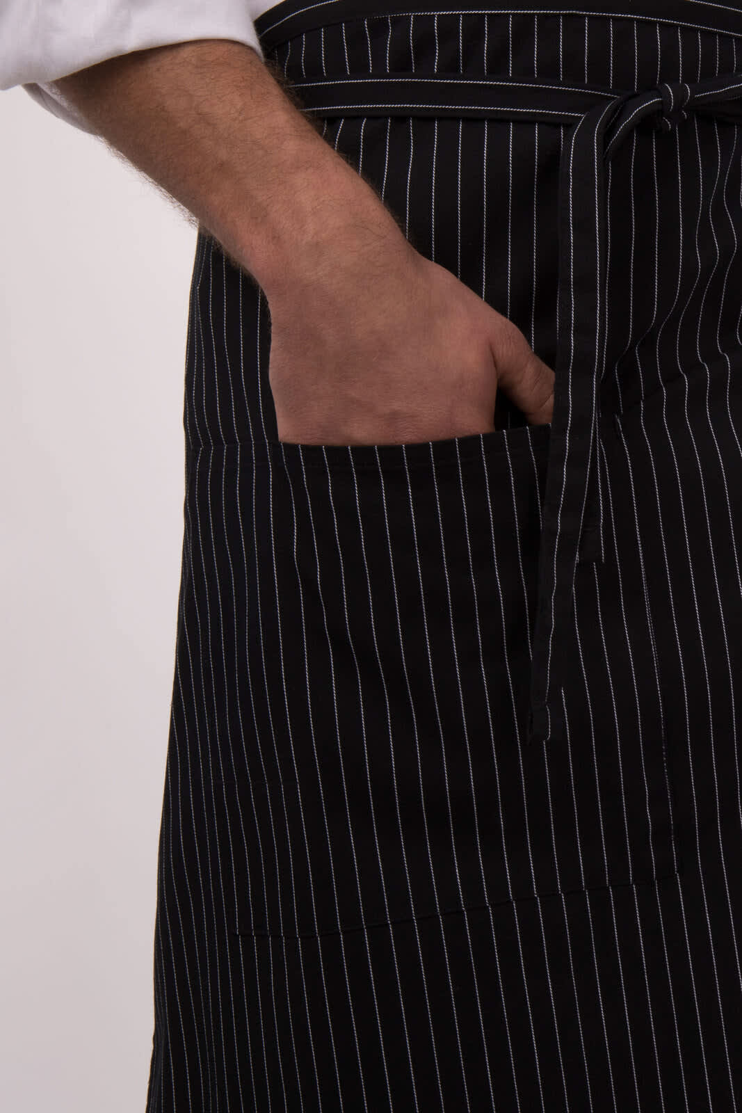 A black and white striped bistro apron featuring a front pocket, tied at the waist.