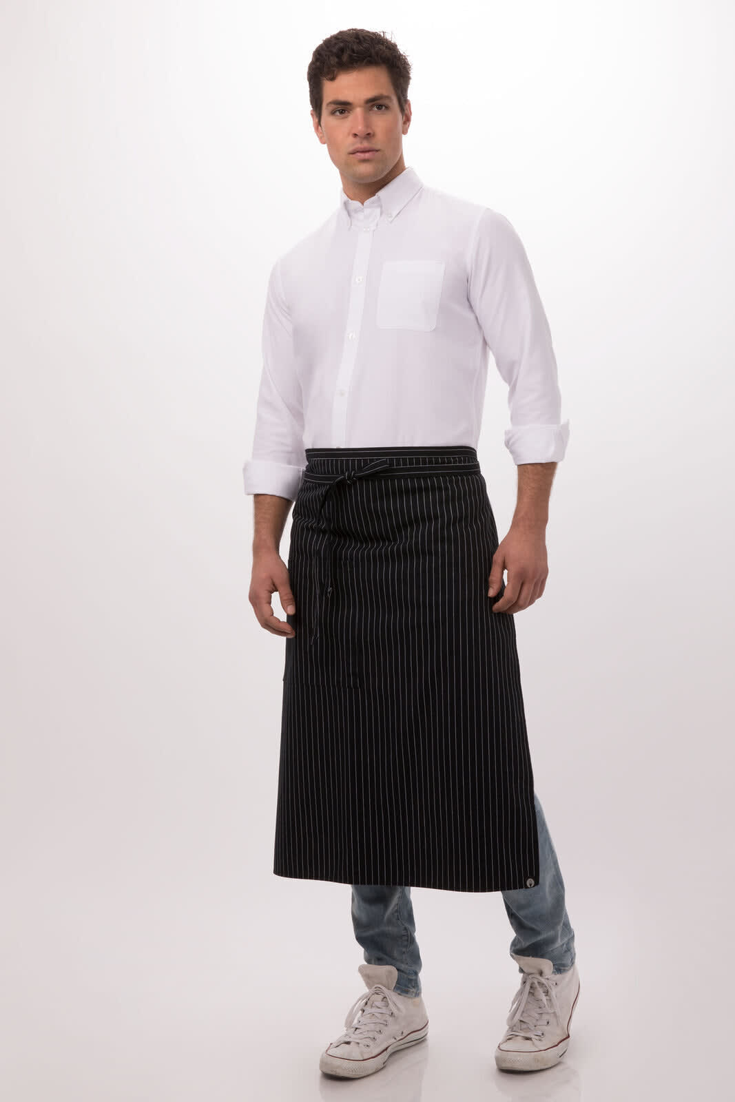 A man stands wearing a black and white striped Bistro Apron over a white shirt and jeans. The image features a logo.