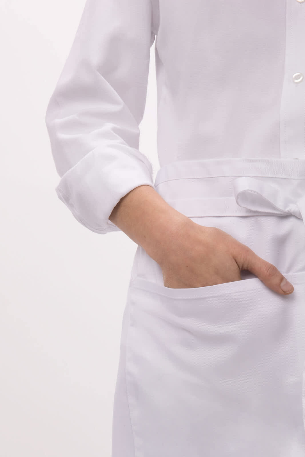 A half bistro apron in white, featuring a pocket and a tie waist, shown on a model's arm.