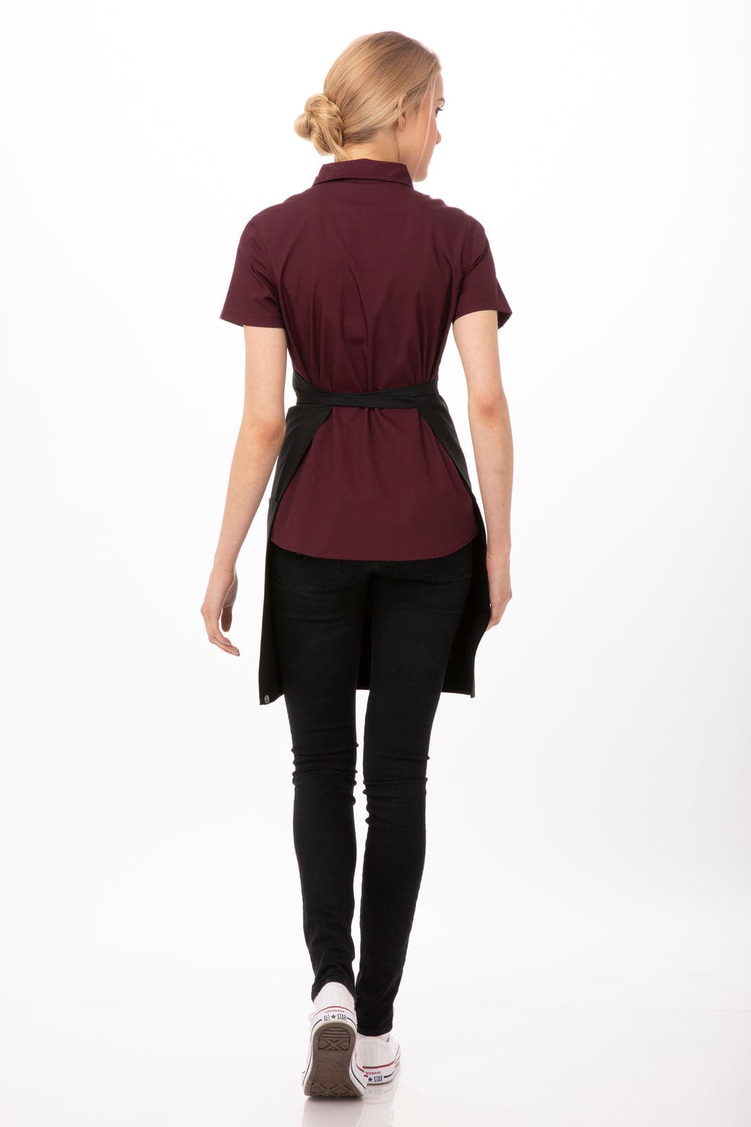 A maroon two patch pocket bib apron worn over a black top, styled with black jeans. The apron features a logo.