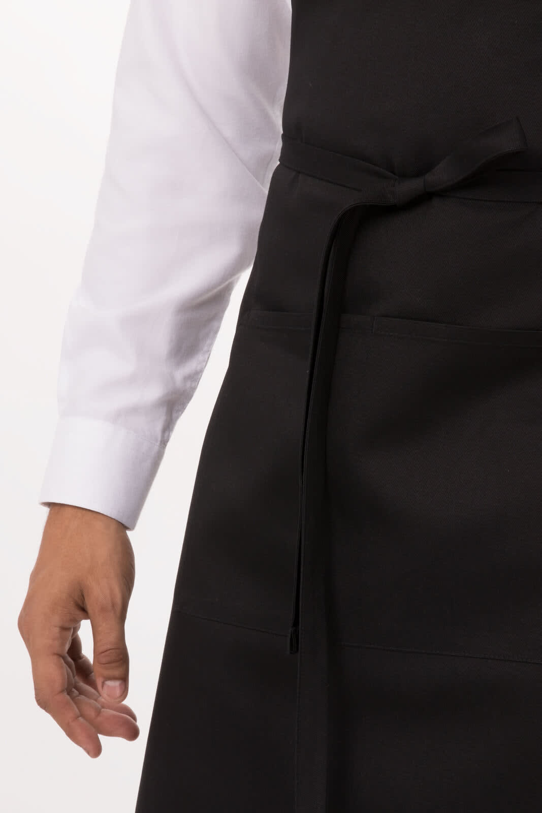 A black bib apron is worn over a white shirt, featuring a waist tie and pocket details.