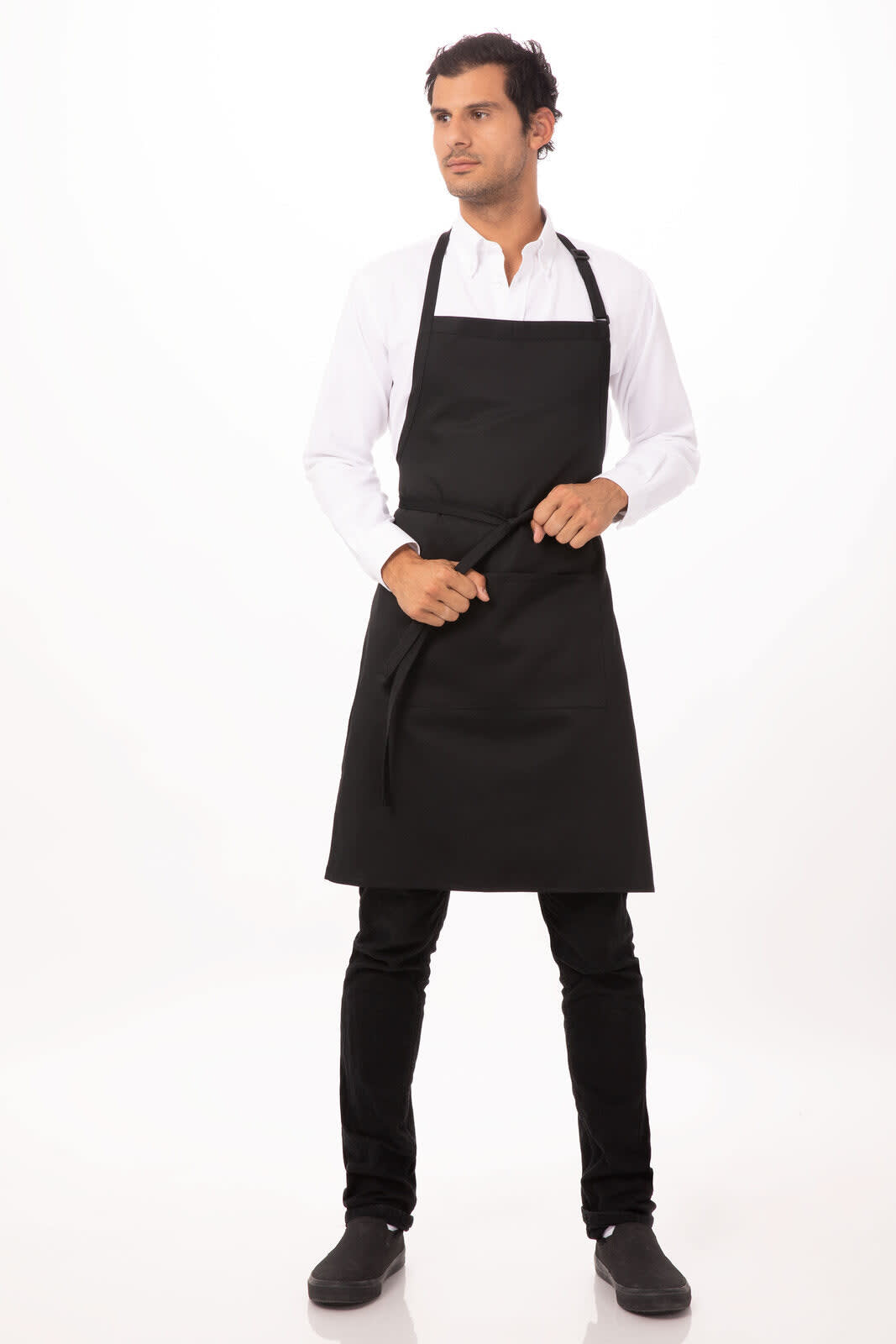 A black bib apron worn by a model, featuring a simple design and adjustable ties, with a logo visible.