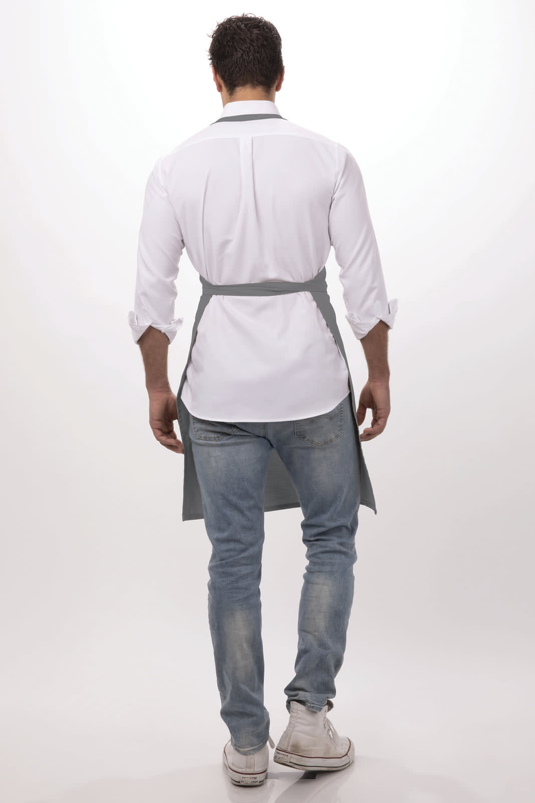 A grey bib apron worn by a man, featuring a simple design with a waist tie, seen from the back.