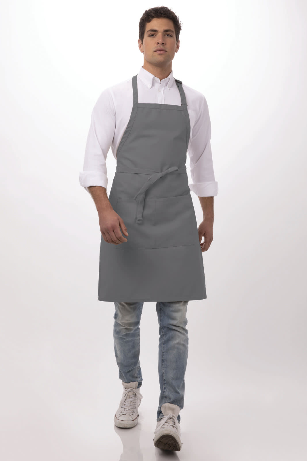 A grey bib apron worn by a model, featuring an adjustable neck strap and a front pocket.