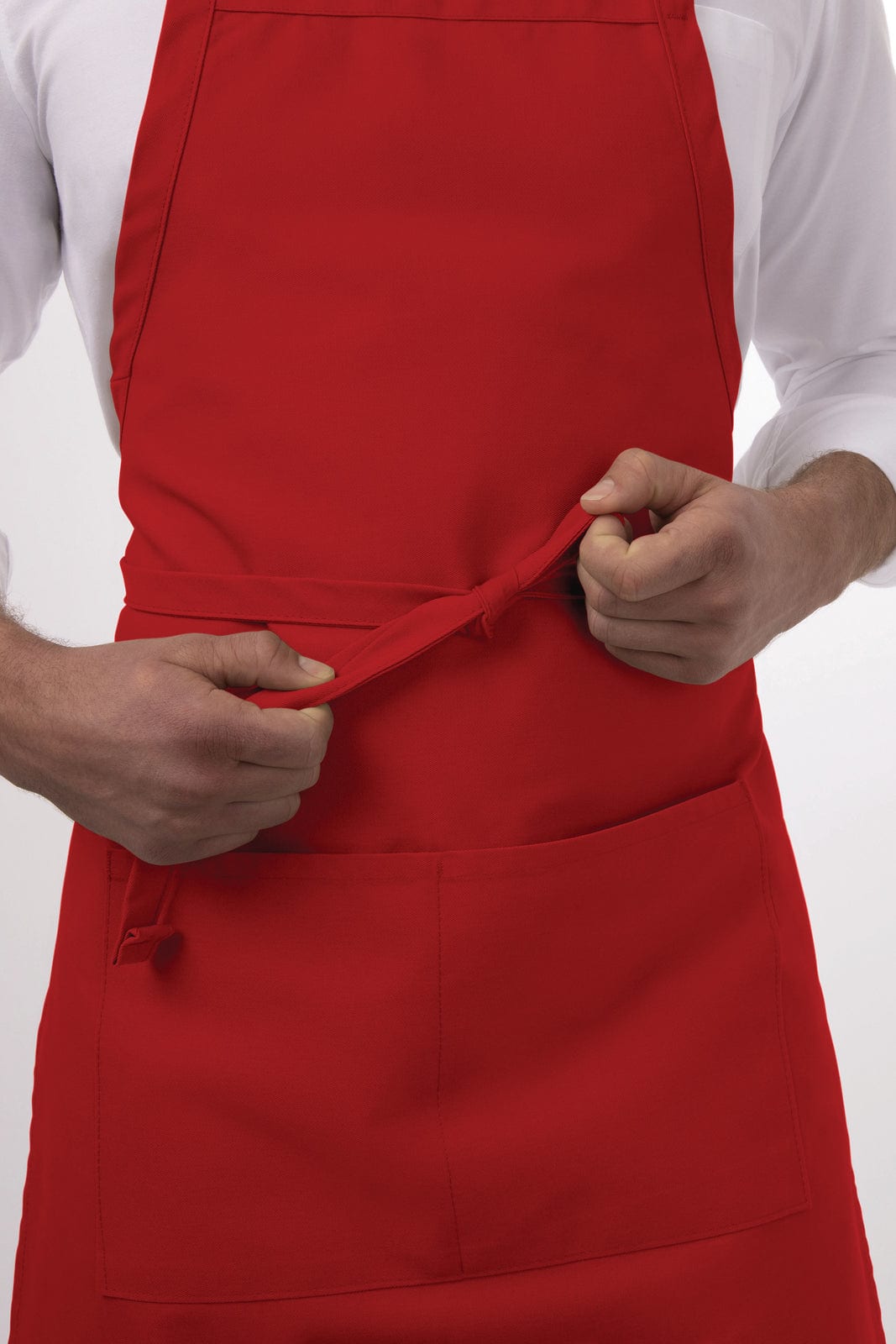 A red bib apron worn by a person, featuring front pockets and adjustable straps. It has a logo on it.