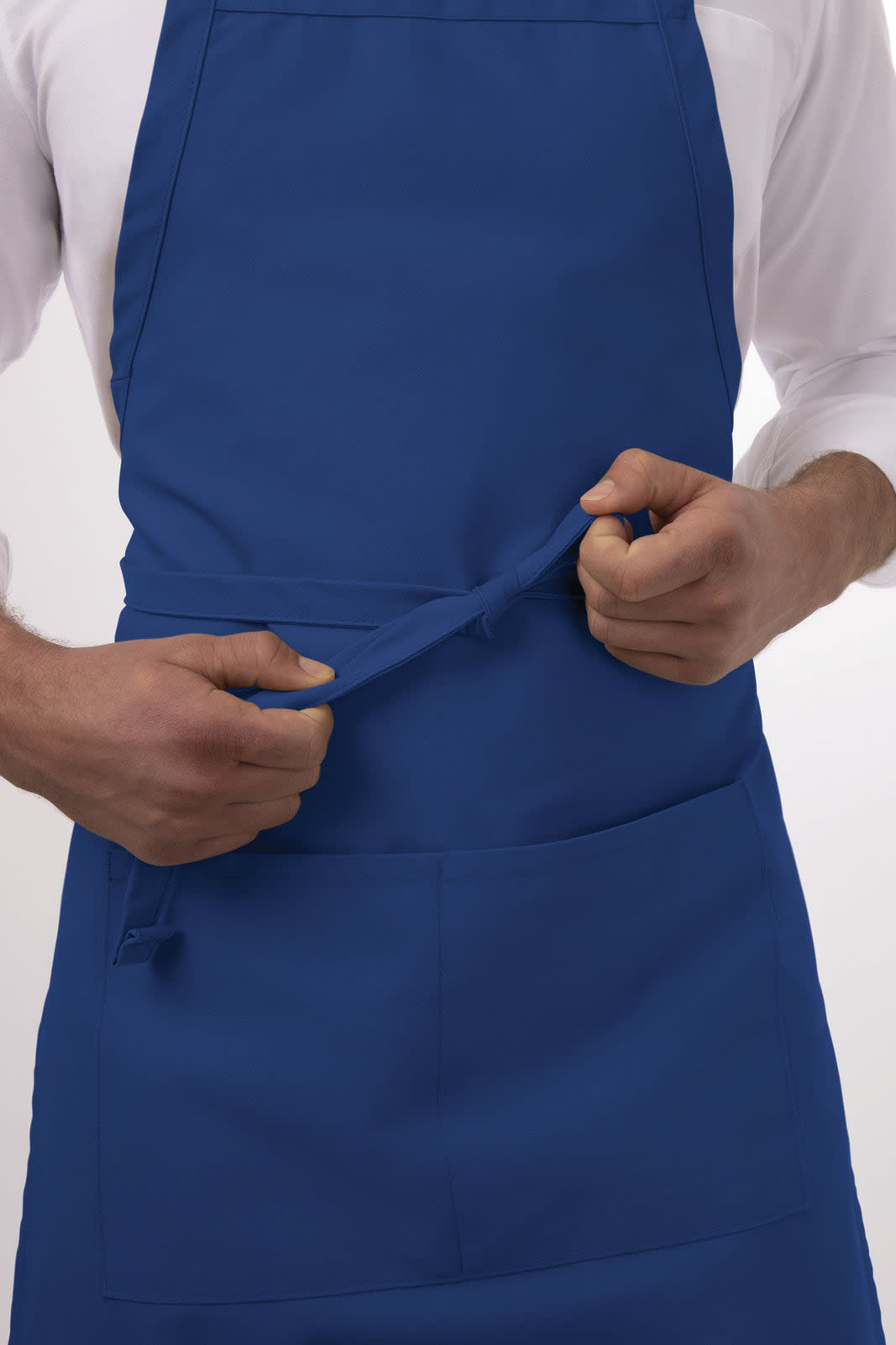 A blue bib apron is being adjusted by a person, featuring a front pocket and a logo.
