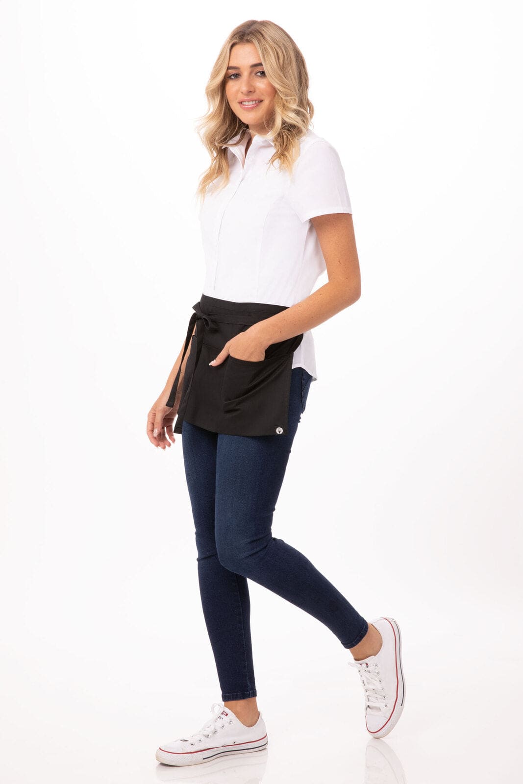 A waist apron in black worn by a woman, complemented by a white shirt and blue jeans, featuring a pocket and a logo.